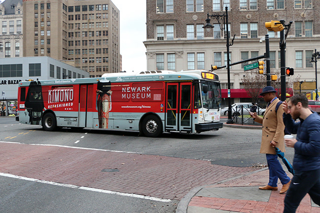 Newark Museum bus wrap photographed in a city intersection